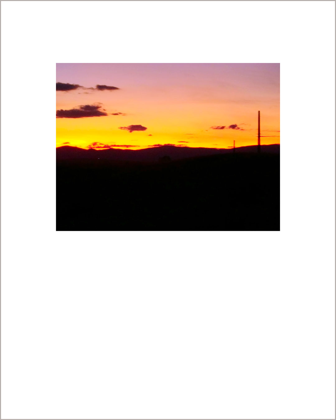 Fotografía horizontal de un atardecer, el suelo es negro y el cielo hace un degradado del naranja al rosa.
